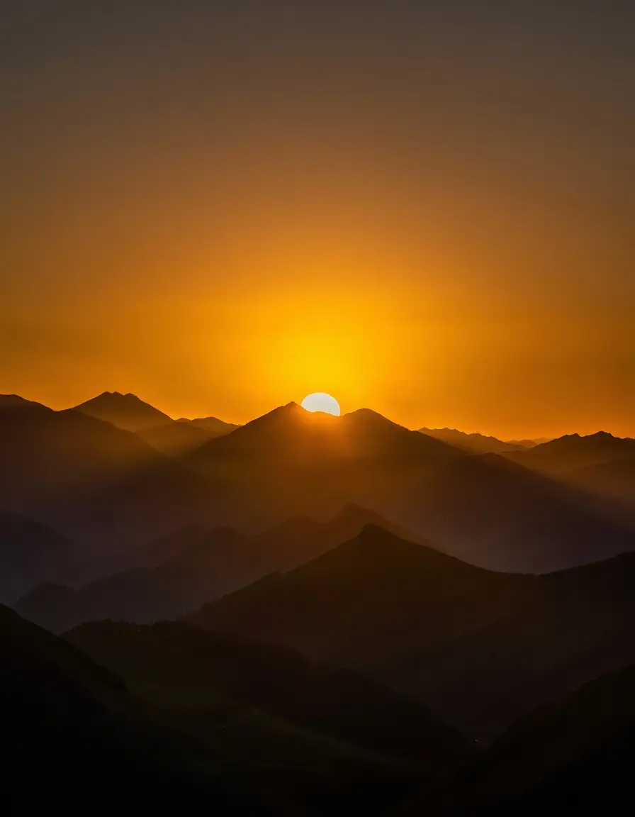 Golden sun over layered mountains